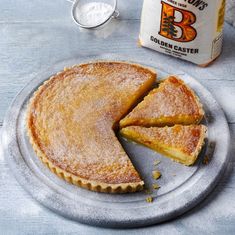 a pie sitting on top of a metal pan next to a jar of butter and spoons