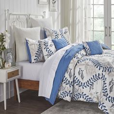 a bed with blue and white comforters in a bedroom