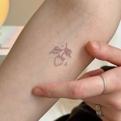 a person with a small tattoo on their arm holding onto her hand and touching the wrist