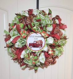 a christmas wreath hanging on the front door with an old truck and candy canes attached to it