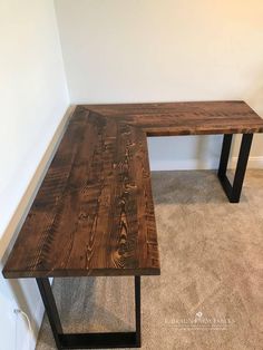 a wooden table sitting in the corner of a room next to a carpeted floor