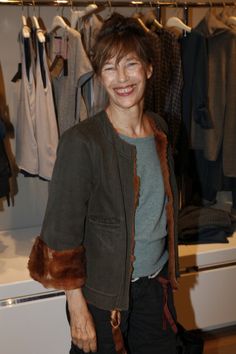 a woman standing in front of a clothes rack