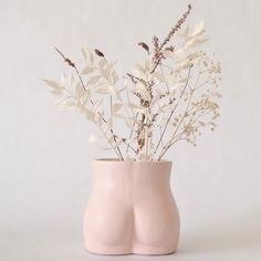 a pink vase with white flowers in it