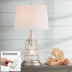 a lamp that is sitting on top of a table next to a book and other items