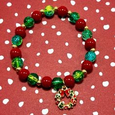 Handmade Christmas Wreath Charm Bracelet With Coral Stones And Cracked Glass! This Stunning Charm Bracelet Features Gorgeous 8mm Red Coral Gemstones, 8mm Green Crackle Glass Beads, Gold-Tone Spacer Beads And An Enamel Christmas Wreath Charm! The Bracelet Measures Approximately 7” Long And Employs Stretchy Elastic Cord. It’s Perfect For Christmas And Also Makes A Beautiful Christmas Gift! Enjoy! Ps 25% Off 3 Or More Items From My Closet! Every Order Ships Same Day!!! Every Purchase Made Of Ashley Beaded Christmas Bracelets, Red Christmas Festive Bracelets, Christmas Charm Bracelet, Affordable Christmas Charm Bracelet For Holidays, Multicolor Christmas Bracelet Jewelry, Red Christmas Holiday Bracelet, Handmade Christmas Wreaths, Coral Stone, Christmas Bracelet