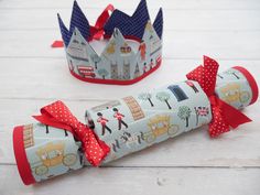 two paper crowns sitting on top of a white table next to each other with red bows