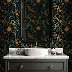 a bathroom sink sitting under a mirror next to a wall mounted faucet in front of a vanity