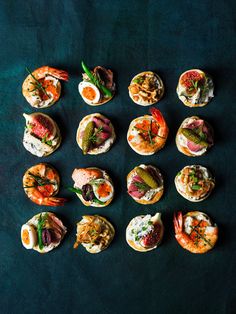 small appetizers are arranged on a blue surface