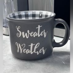 a black and white coffee mug with the words sweater weather on it's side