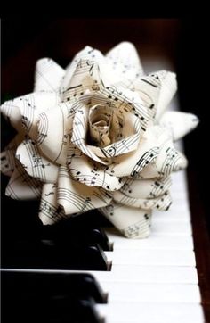 a paper rose sitting on top of a piano keyboard