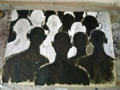 an art work with black and white silhouettes painted on the paper in front of it