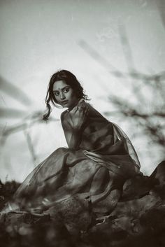 black and white photograph of a woman sitting on the ground