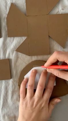 someone is cutting out cardboard shapes with scissors