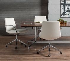 a wooden table topped with white chairs next to a window