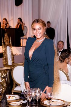 a woman standing in front of a table with wine glasses and silverware on it