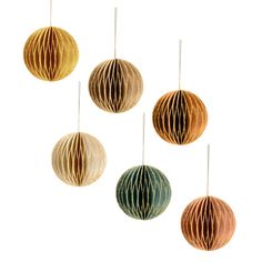 four paper ball ornaments hanging from strings on a white background with clippings in the middle