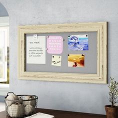 a wooden table topped with two vases filled with flowers next to a framed photo