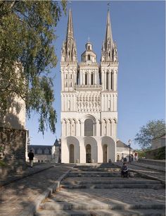 the large cathedral has many steeples and spires on it's sides, as well as steps leading up to them