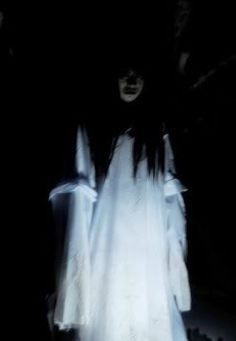 a ghostly woman standing in the dark