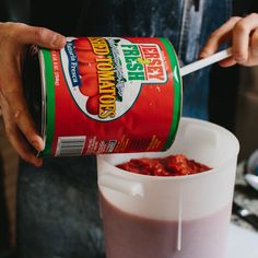 a person pouring sauce into a container