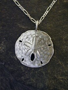 "This Atlantic Sand Dollarpendant is Sterling Silver. The included chain is a Sterling Silver Figaro 50 chain. You may choose 16, 18 or 20 inch at the same price. Other length available at sightly higher prices. This Atlantic Sand Dollar pendant measures 1\" in diameter. I hand cast all my pieces using the lost wax casting method. Please ask your needs. You may call me with questions, often I am out so please use my machine. 831-476-3176. Satisfaction Guaranteed! I send items USPS First Class un Sand Dollar Pendant, Artisan Earrings, Wax Casting, Lost Wax Casting, Sand Dollar, Throat Chakra, Lost Wax, Hand Cast, Sterling Silver Chain