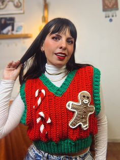 a woman wearing a christmas sweater with a gingerbread man on it's chest