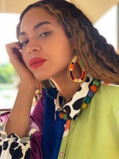 a close up of a person with a cell phone near her ear and wearing earrings