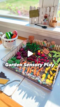 a cake that is sitting on a table in front of a window with the words garden sensory play