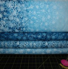 three pieces of blue fabric with snowflakes on them