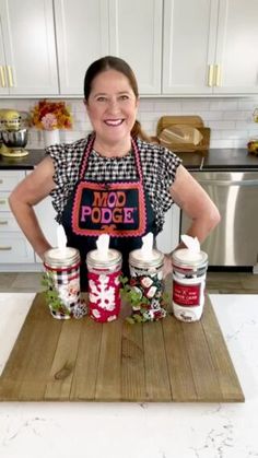 a woman standing in front of some food on a cutting board with ketchup and mayonnaise