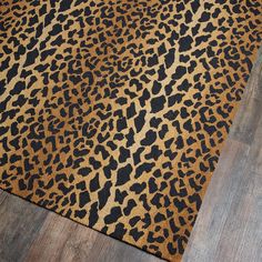 a leopard print rug with wood flooring in the background and an animal pattern on it