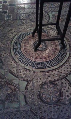 the floor is covered in intricate designs and patterns, with a bar stool next to it