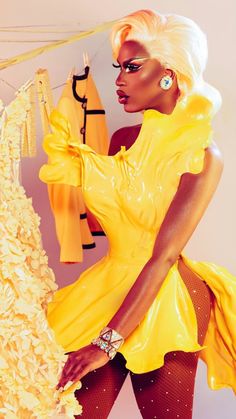 a woman in a yellow dress is standing next to some clothes