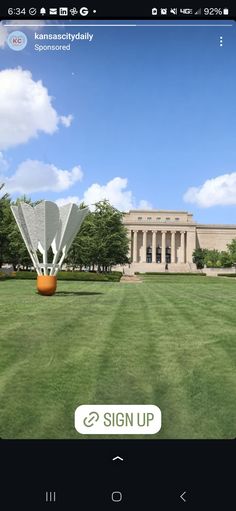 an image of a large building in the middle of a field with trees and grass