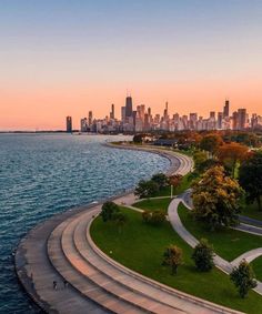 an aerial view of the city skyline and lake michigan at sunset, with curved concrete walkways in foreground