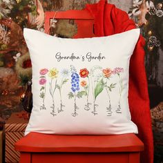 a red chair with a white pillow on it that says grandma's garden and flowers