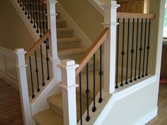 a stair case in a house with wood floors and white railings on the stairs