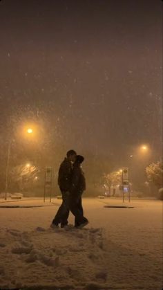 two people walking in the snow at night