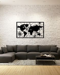 a living room with a sectional couch and coffee table in front of a white brick wall