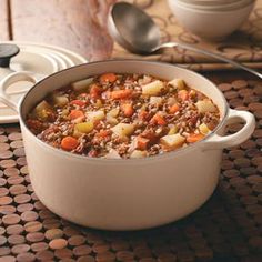 a pot filled with stew sitting on top of a table