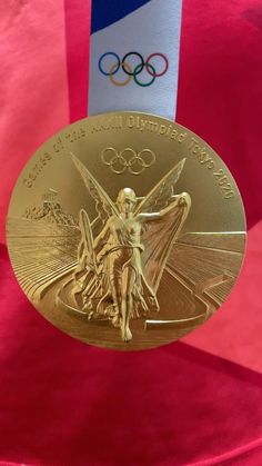 a gold medal with the olympic logo on it