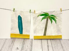 two towels hanging on a clothes line with a palm tree and surfboard in the background