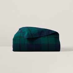 a green and black plaid blanket sitting on top of a table