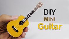 a person holding a small yellow ukulele with the words diy mini guitar