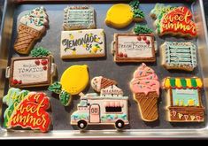 decorated cookies in the shape of food trucks and ice creams are displayed on a tray