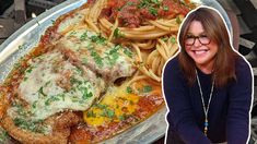 a woman sitting in front of a plate of food with spaghetti and meat on it