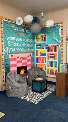 a classroom with bean bag chairs and bookshelves on the wall, in front of a bulletin board