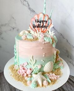 a birthday cake decorated with pink, blue and green frosting