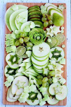 a cutting board topped with sliced apples and kiwis