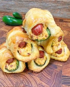 hot dogs wrapped in bread with peppers on the side